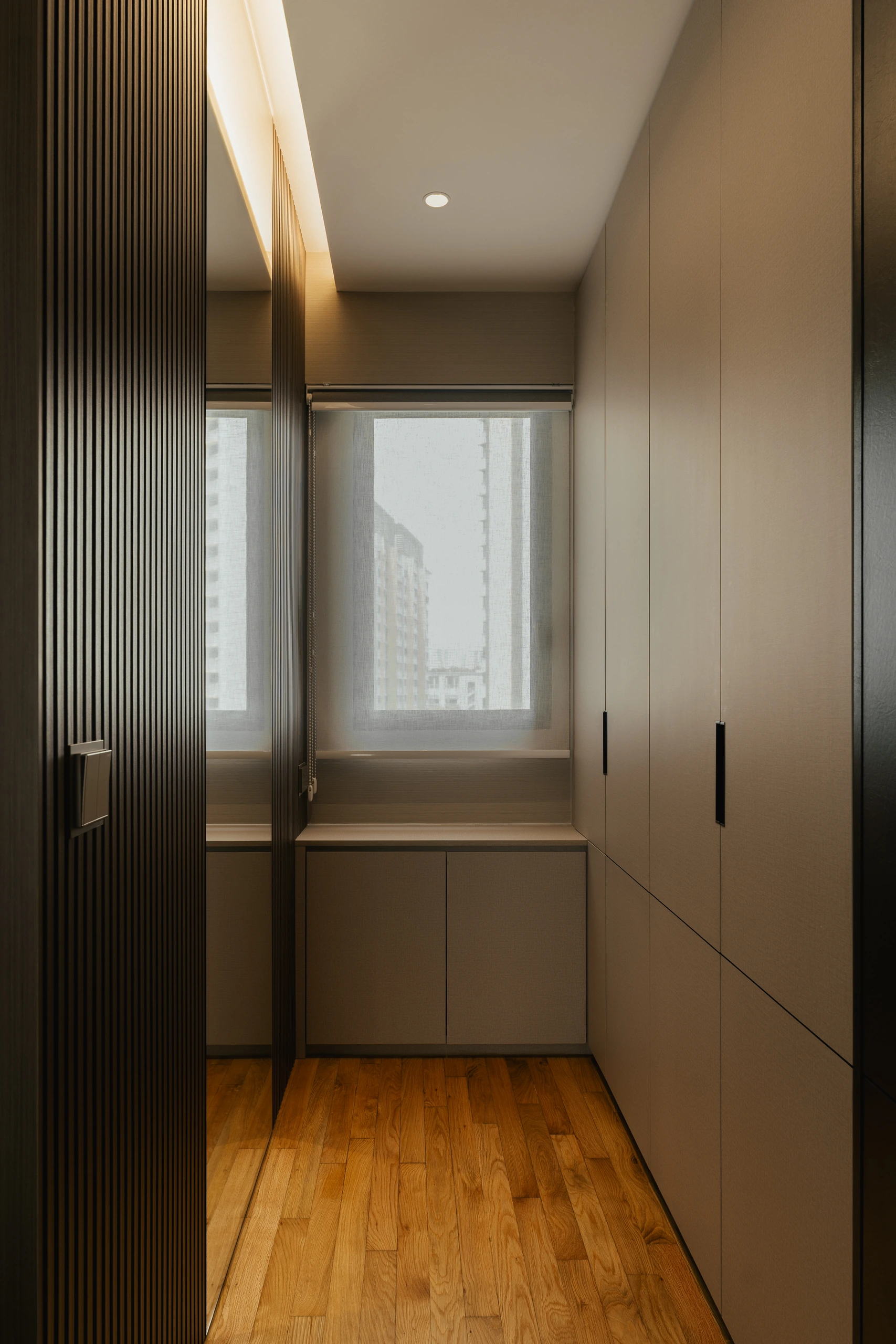 Walk-through wardrobe with full-height cabinetry by Edgeline Planners