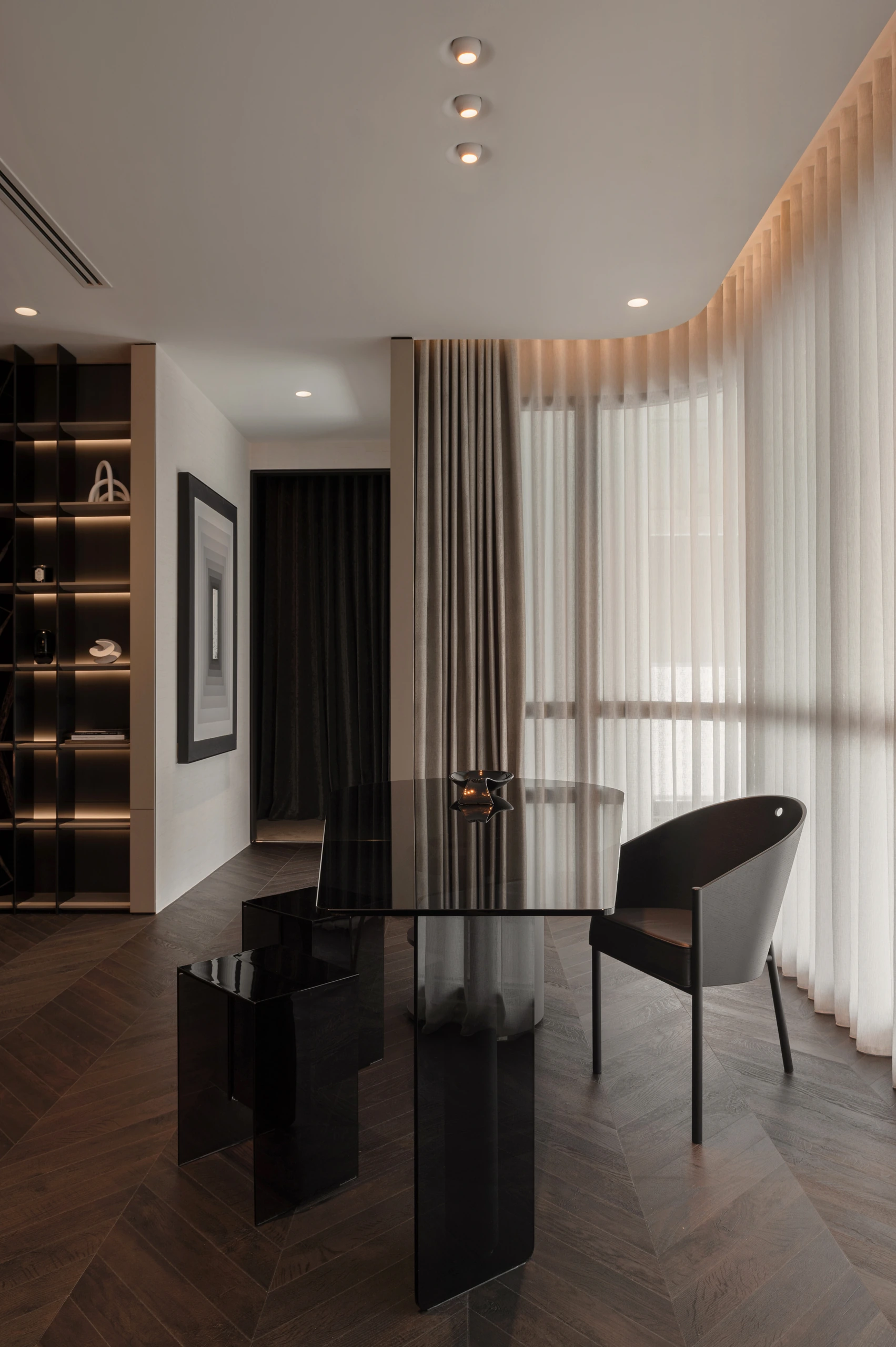 Reflective black dining table beside full-height curtains by Edgeline Planners
