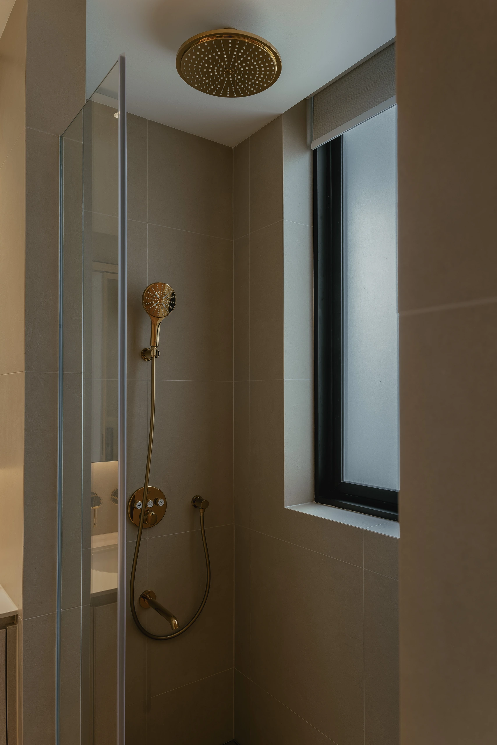Gold rain shower beside a dark-framed window by Edgeline Planners