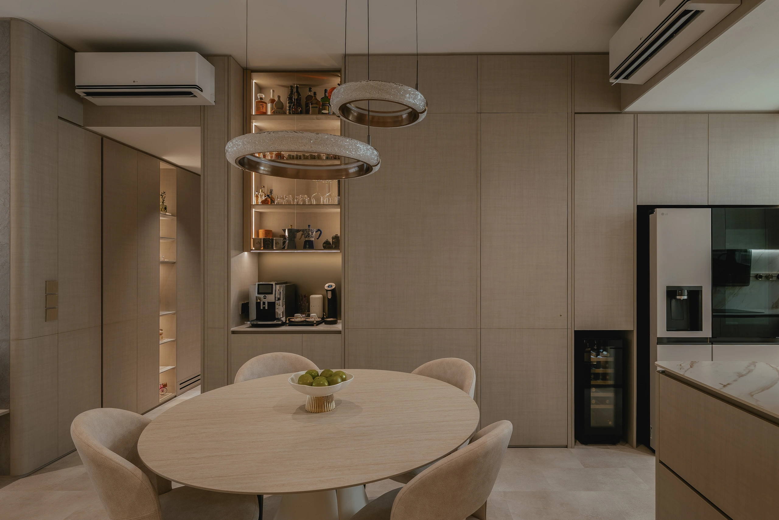 Round dining table beside the kitchen and coffee bar by Edgeline Planners
