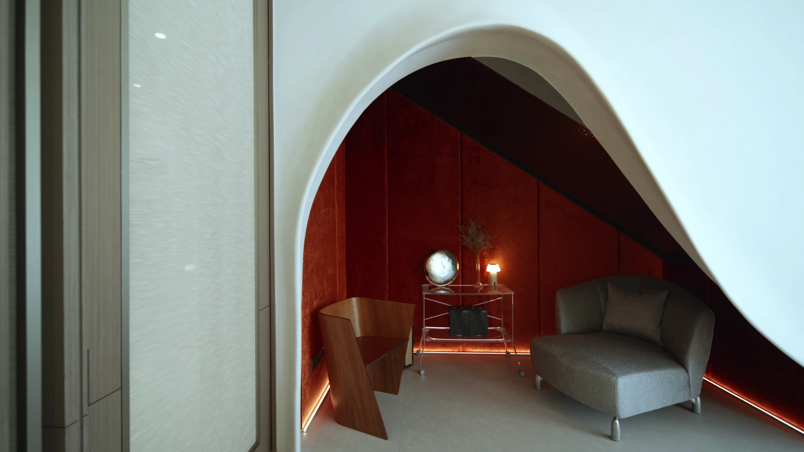 Red-lined lounge framed by sculptural arch by Edgeline Planners
