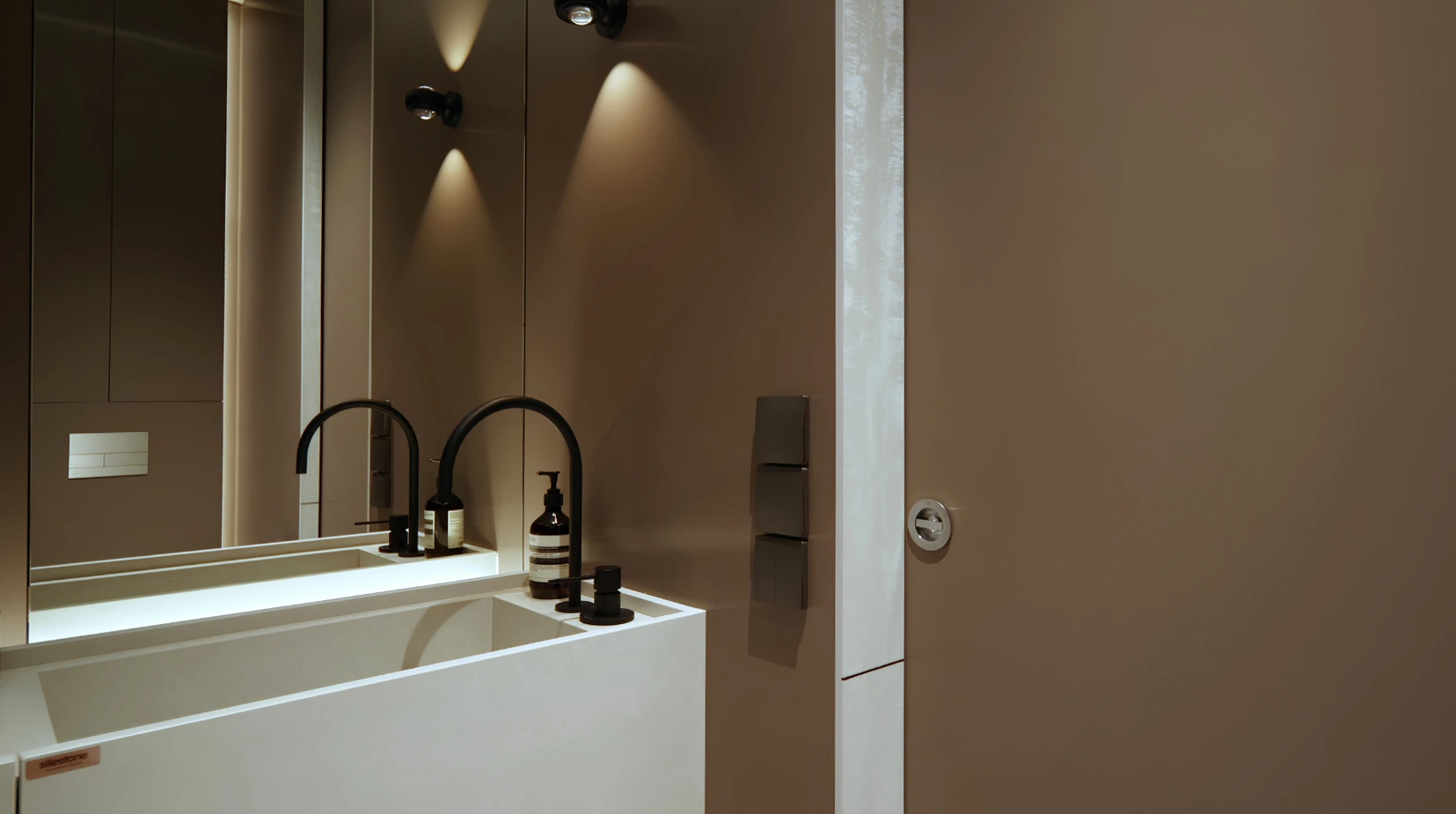 Floating white powder-room vanity with black fittings by Edgeline Planners