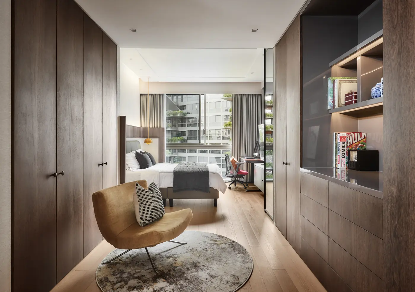 Secondary bedroom with warm walnut, reading chair and city view