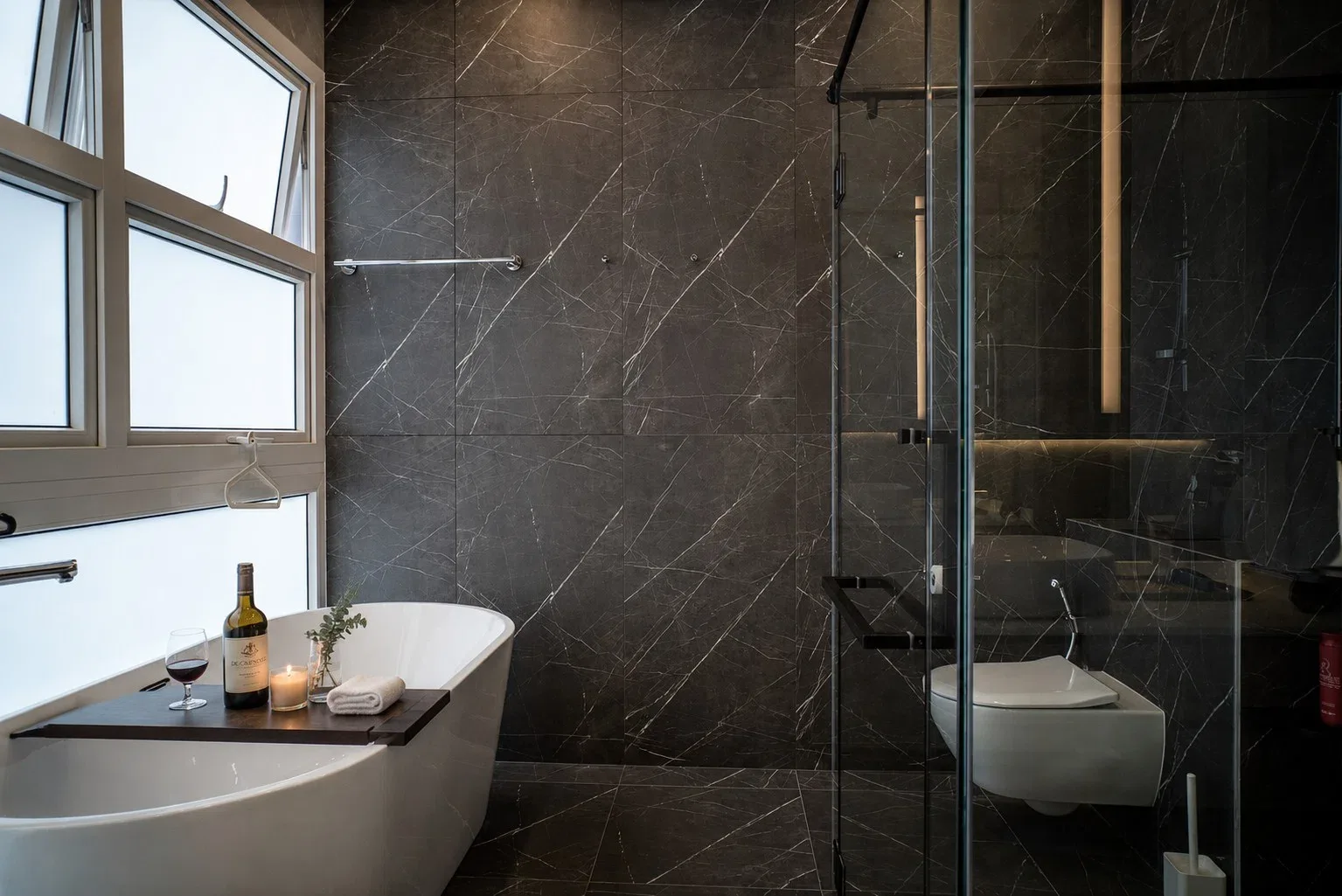 J Concept Designers &mdash; master bathroom with dark stone surfaces, freestanding tub and glass shower