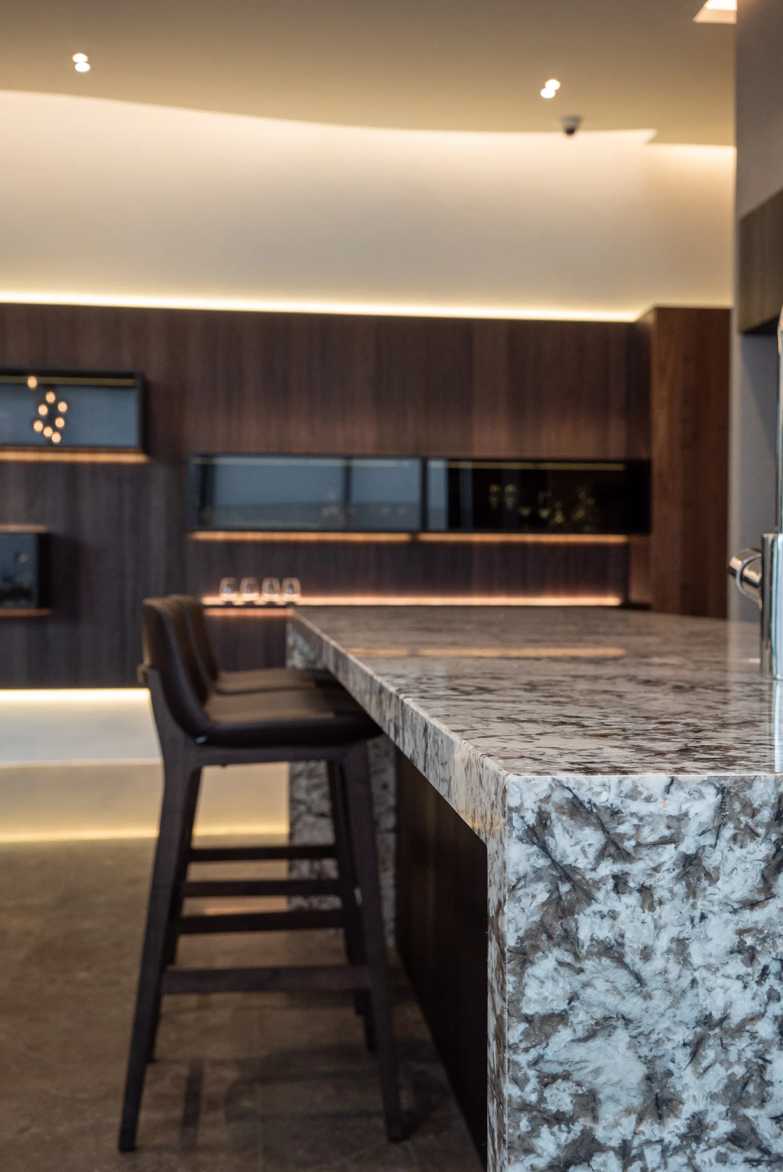 J Concept Designers &mdash; stone island close-up with dramatic veining and leather bar stools