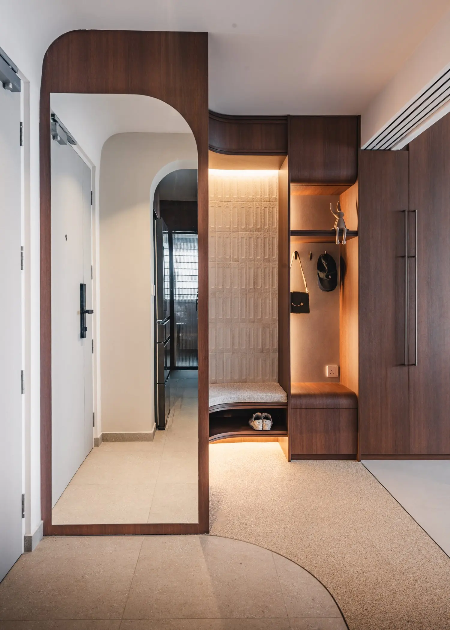 Rondure entrance with curved timber settee and illuminated display shelving