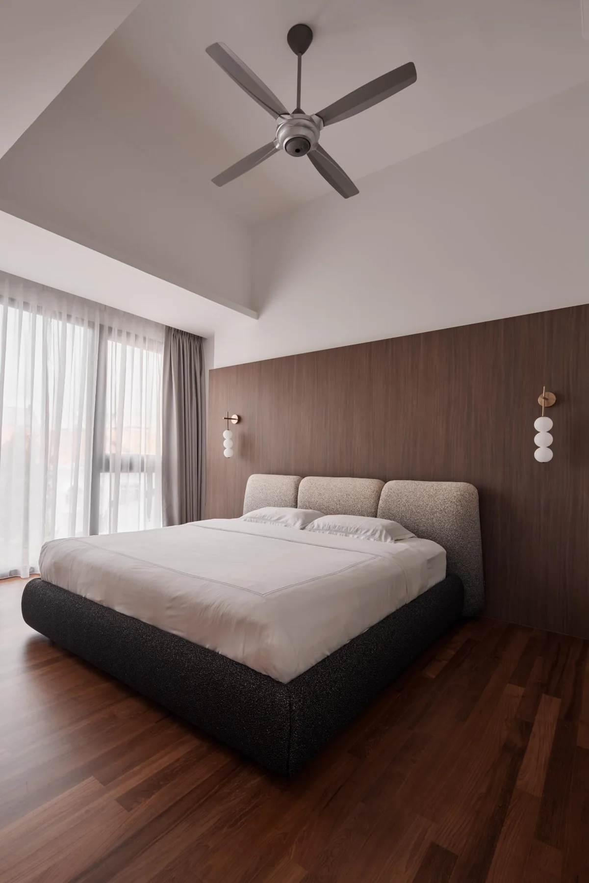 Master bedroom with full-height ceiling and timber feature wall
