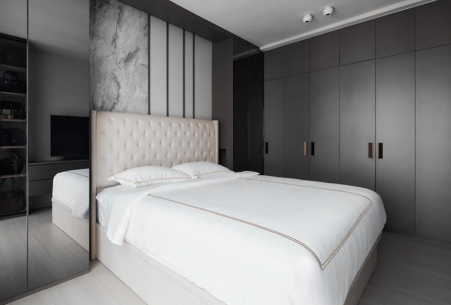 Master bedroom with layered feature wall and dark cabinetry