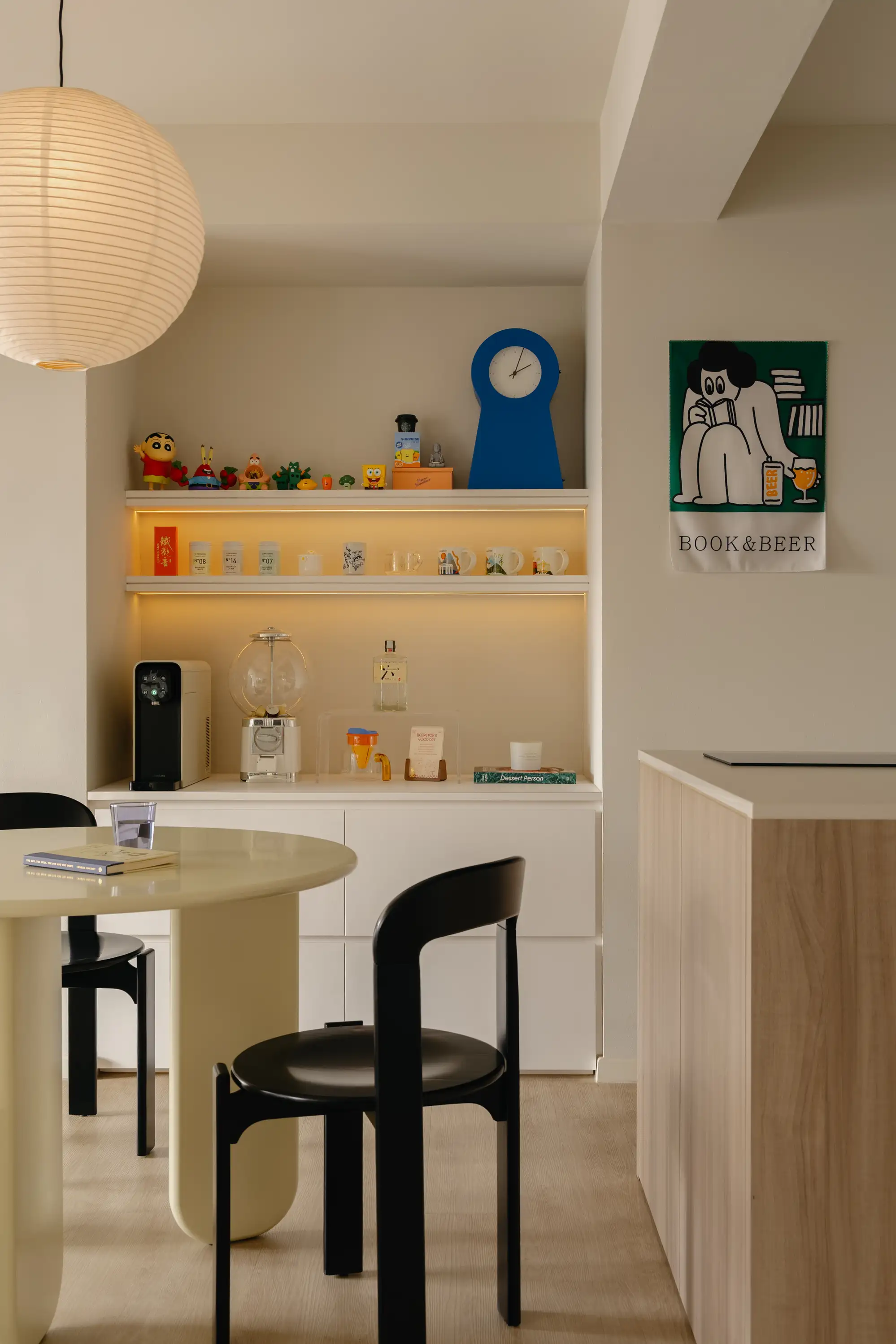 Dining area beside the kitchen display ledge and pale timber cabinetry