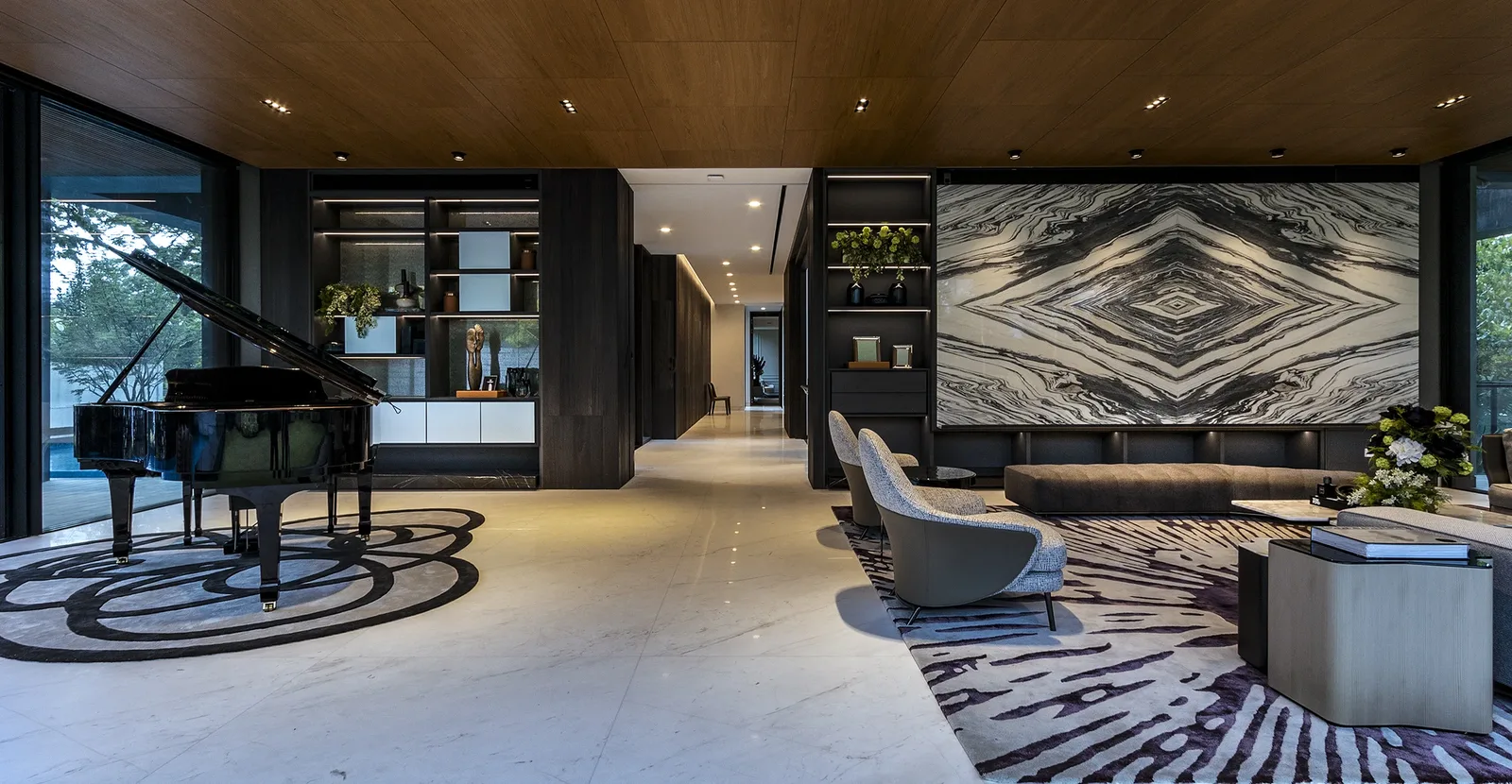 SuMisura &mdash; living hall with grand piano, bookmatched marble feature wall and illuminated display shelving